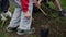 Kids gathering soil around fresh planted blueberry plant