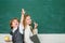 Kids gets ready for school. Couple of little girl and boy in classroom. Schoolgirl helping pupils studying at desks in