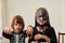 Kids in halloween costumes on white wall background