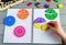 Kids hand moves colorful math fractions on gray wooden background or table. Interesting creative funny math for kids. Education,