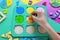 Kids hand moves wooden parts of fractions. Wooden toys on colorful paper. Educational fractions. Toys for kindergarten, preschool