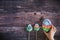 Kids hand taking a colorful sweet homemade meringues in the form of eggs on wooden background. Many sweet zephyrs