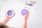 Kids hands holding a homemade plastic jewelry box and thermomosaic beads on white background