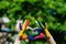 Kids hands painted in bright colors make a heart shape on summer nature background