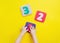 Kids hands playing with puzzles in a number shape on yellow background