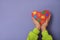 Kids hands with a red heart with pieces of colored puzzles inside