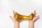 Kids hands stretching and playing golden glitter slime toy on white background. Isolated.