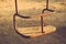 Kids hanging swing rusty metal with wooden seat outdoors