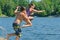 Kids having summer fun jumping off dock into lake