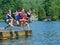 Kids having summer fun jumping off dock into lake