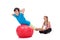 Kids helping each other exercising with a large gymnastic rubber