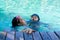 Kids hold on poolside in swimming suit play and swim in water pool in resort