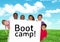 Kids holding card showing text boot camp in front of blue sky and grass