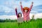 Kids holding laptop and rise hand in rice field on blurred blue sky background