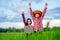 Kids holding laptop and rise hand in rice field on blurred blue sky background