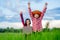 Kids holding laptop and rise hand in rice field on blurred blue sky background