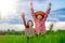 Kids holding laptop and rise hand in rice field on blurred blue sky background