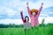 Kids holding laptop and rise hand in rice field on blurred blue sky background