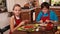 Kids at home making a pizza spreading and tasting the sauce