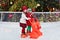 Kids ice skating in winter park rink. Children ice skate on Christmas fair. Little girl and boy with skates on cold day. Snow