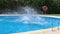 Kids jumping into the blue water of the pool