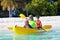 Kids kayaking in ocean. Family in kayak in tropical sea