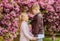 Kids in love pink cherry blossom. Love is in the air. Couple adorable lovely kids walk sakura garden. Tender love