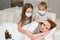 Kids in masks take temperature of sick mother.