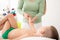 Kids massage concept background. Young female massage therapist giving a 6 year old boy arms massage. Physical therapy.