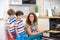 Kids and mother baking. Two children and parent cooking. Little boy and brother boy cook and bake in a white kitchen with modern