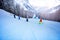Kids mountain ski down slope in school formation