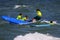 Kids in neon green shirts riding on waves while surfing at Bunger Surf Camp