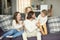 Kids and parents laughing having fun playing sitting on sofa