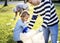 Kids picking up trash in the park with parents