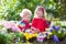 Kids planting flowers in blooming garden