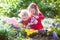 Kids planting flowers in blooming garden