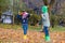 Kids play with maple leaves in park