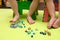 Kids play with mosaic pieces, glass stones. Orthopedic game, gymnastics with valgus, massage and stimulation of the muscles of the