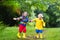 Kids play in rain and puddle in autumn