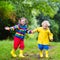 Kids play in rain and puddle in autumn