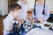 Kids playing with electrical robot while visiting robotics exhibition