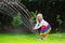 Kids playing with garden sprinkler