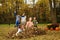 Kids playing and jumping in leaves