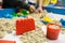 Kids playing plastic mold toys with sand on sandbox.