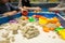 Kids playing plastic mold toys with sand on sandbox.