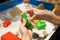 Kids playing plastic mold toys with sand on sandbox.