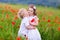 Kids playing in red poppy flower field