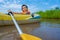 Kids playing and rowing boat in river of organic farm in rural on blue sky and white clouds background