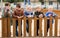 Kids playing with smartphones near wooden fence