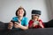Kids playing video games at home, boy and girl with remote controls indoors